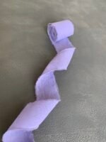 Світло-фіолетова стрічка з необробленими краями, розкладена хвилею