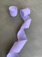 Згорнута світло-фіолетова бавовняна стрічка з частково розмотаною частиною