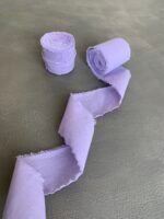 Стрічка з необробленими краями, частково розмотана поряд з рулоном